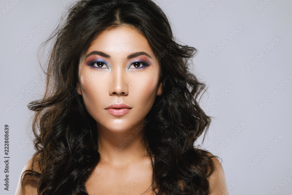 Obraz premium Young asian woman with a beautiful curly hair and make-up