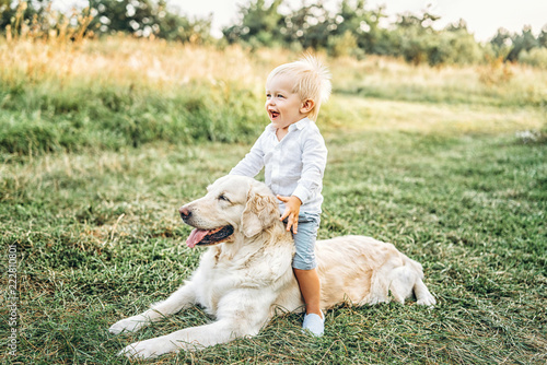 Pretty little baby boy have fun with dog