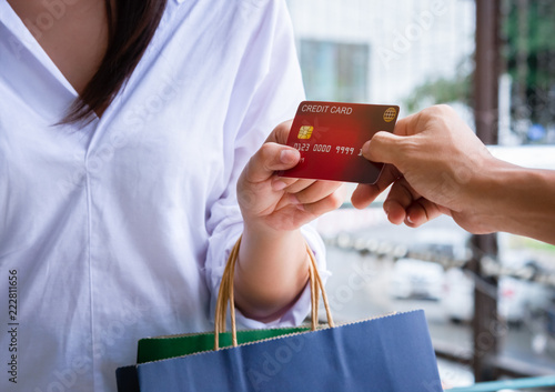 Close-up of woman giving a credit card to shopping.