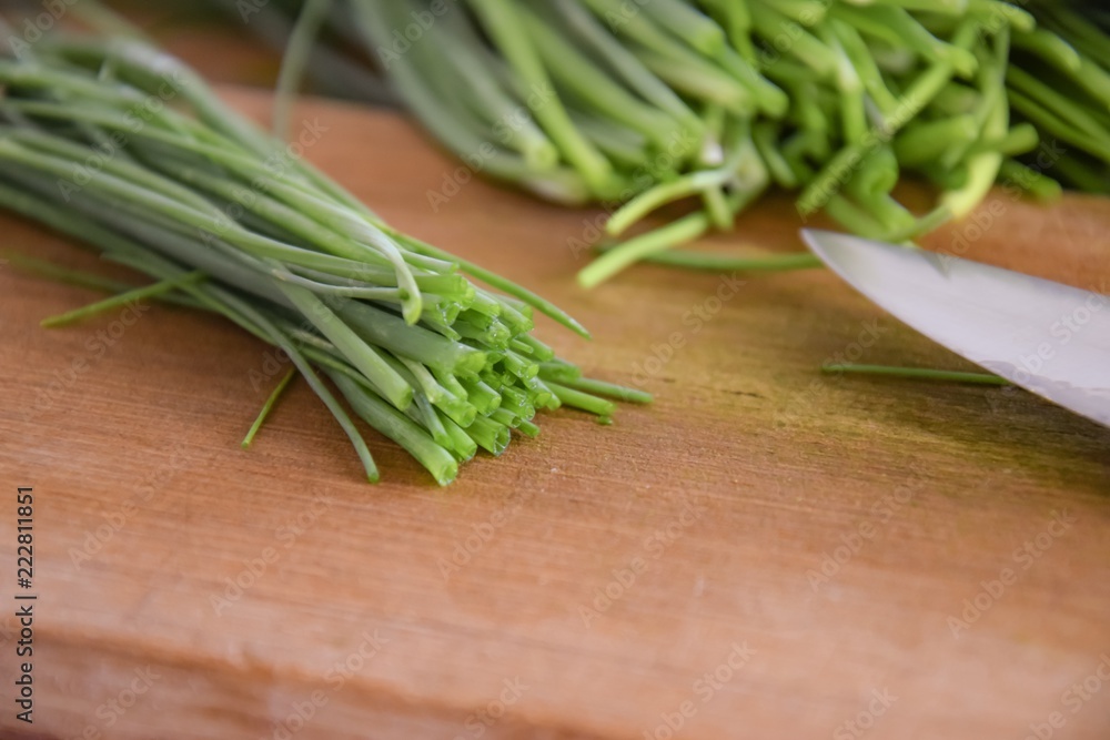 fresh bunch of chieves on a wooden cutting board fresh bunch of chieves on a wooden cutting board