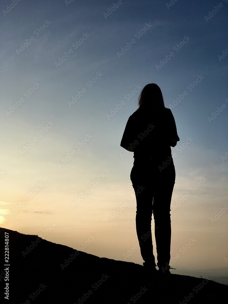 Silhouette of a young woman stood on Ilkley Moor, Yorkshire, England