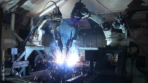 Team industrial robot are movement welding automotive part in factory