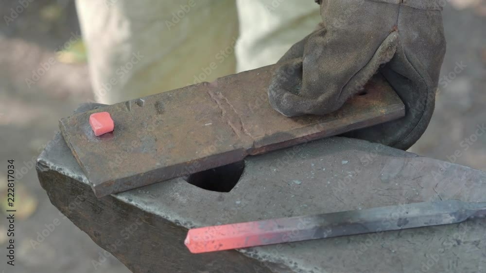 blacksmith makes nail head of red-hot bar on anvil blacksmith makes nail head of red-hot bar on anvil