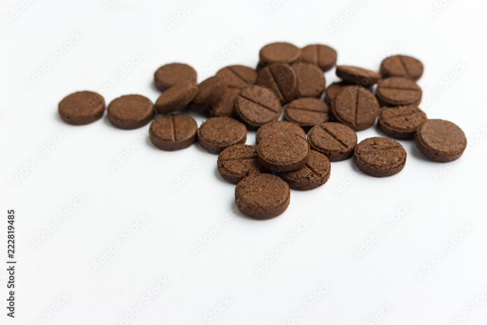 Few brown detox pills on white background