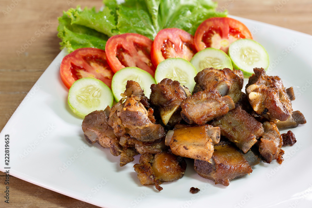 Fried deep pork ribs in white dish with vegetable thai food Fried deep pork ribs in white dish with vegetable thai food