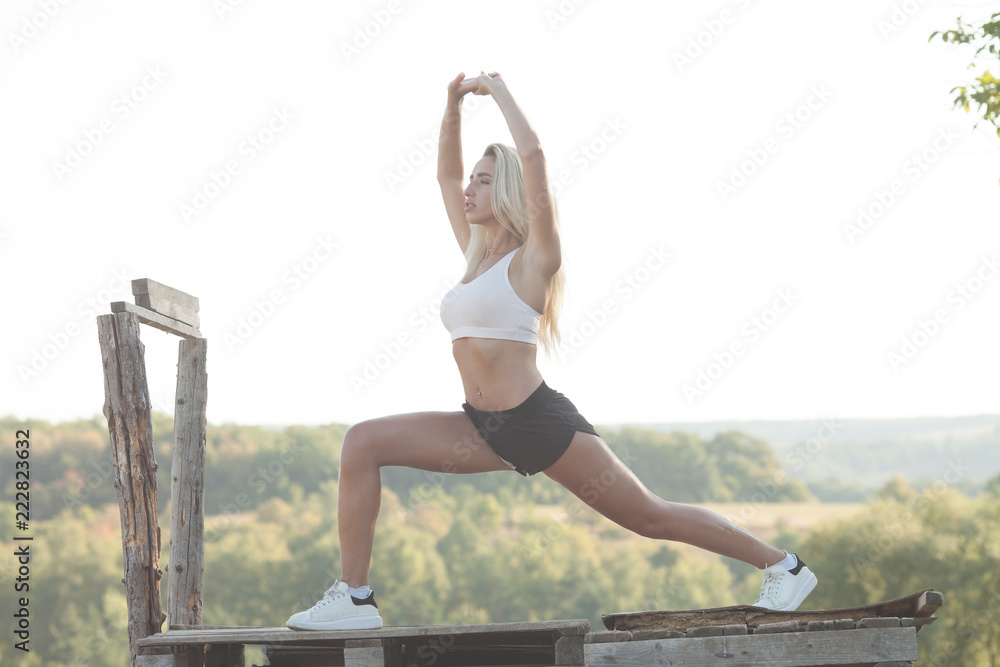 Fototapeta premium Young fitness woman doing exercises outdoor.