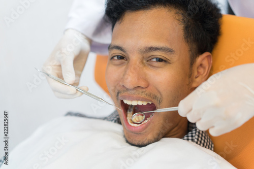 close up asian patient man open mouth for dentist exam with dental tool , health and lifestyle peope concept photo