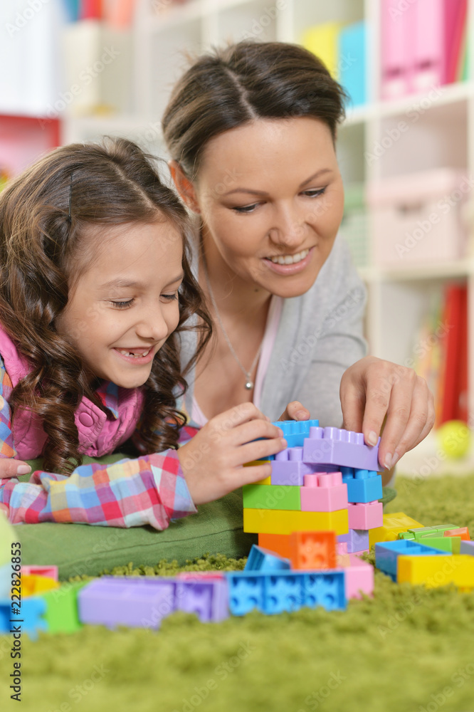 Curly little girl and her mother playing Curly little girl and her mother playing