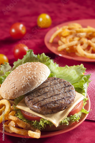 Beef Burger with bell pepper and lettuce with cherry red and yellow tomato on Red background 