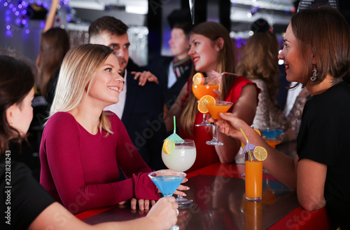 Woman with colleagues on corporate party in bar
