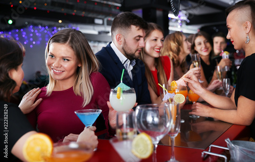 Woman with colleagues enjoying corporate party in bar