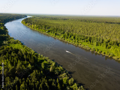 Ob river flows through the taiga. River landscape, beautiful sky reflection in water. Vasyugan Swamp from aerial view. Tomsk region, Siberia, Russia