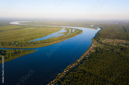 Ob river flows through the taiga. River landscape, beautiful sky reflection in water. Vasyugan Swamp from aerial view. Tomsk region, Siberia, Russia
