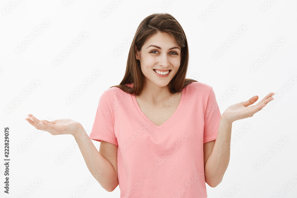 Do not want know. Indifferent and carefree charming woman in pink t-shirt, shrugging and spreading palms in clueless and unaware gesture, smiling broadly, having no interest, being careless Do not want know. Indifferent and carefree charming woman in pink t-shirt, shrugging and spreading palms in clueless and unaware gesture, smiling broadly, having no interest, being careless