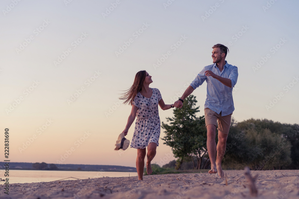 Couple walking on the beach at sunset