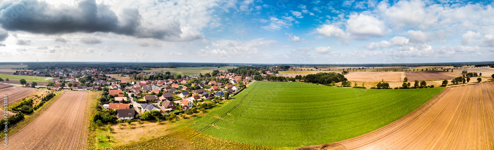 Aerial view of a small village in northern Germany with large arable land at the edge of the village, Panorama in high resolution.