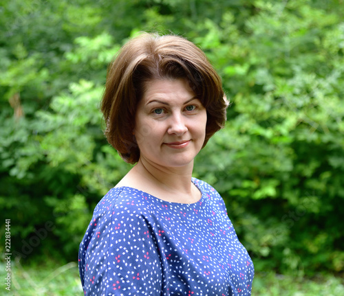 portrait of woman in blue dress in nature in summer