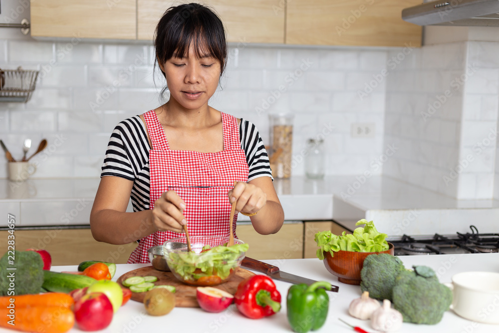 Healthy food Asian woman is cooking salad in kitchen, female preparing the vegetables and fruit at her house