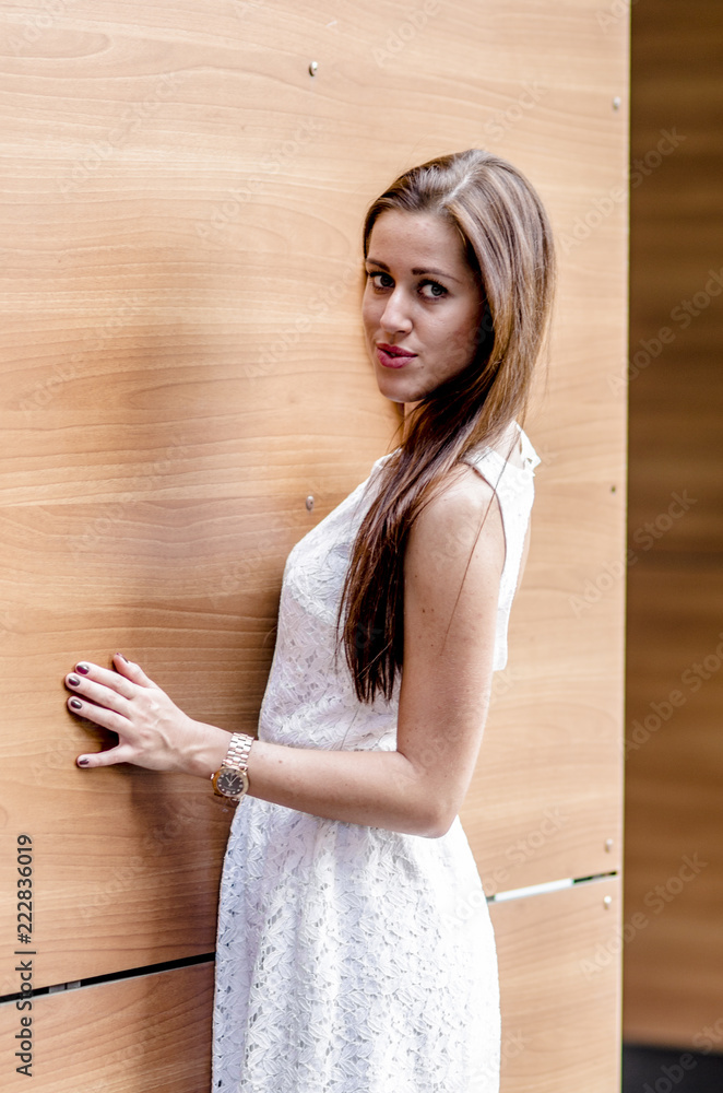 Young girl in a white dress near a wooden wall
Young girl in a white dress near a wooden wall