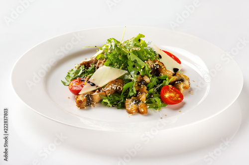 Plate with fried chicken meat served with salad, tomato, parmesan and sauce isolated at white background.