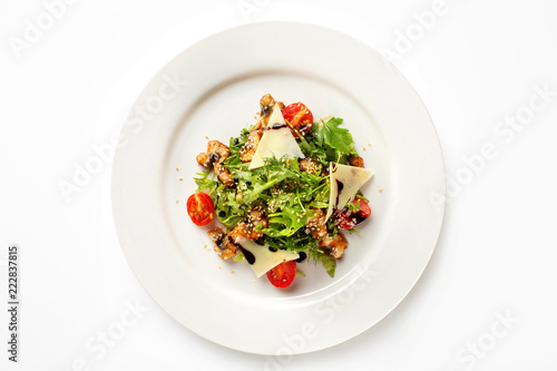 Top view plate with fried chicken meat served with salad, tomato, parmesan and sauce isolated at white background.