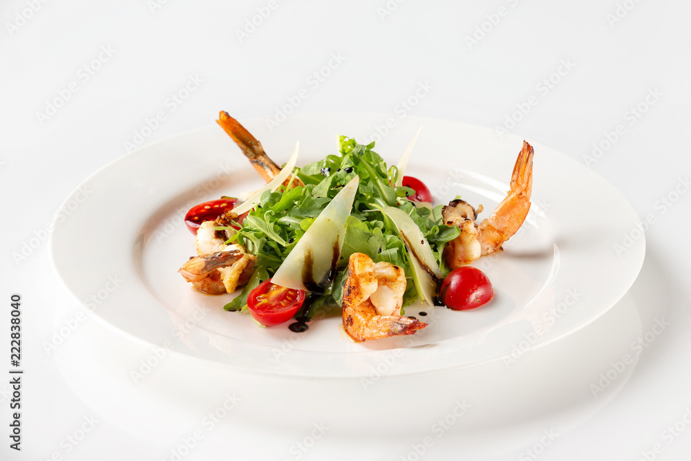 Plate of delicious salad with fried prawns, tomato, parmesan and green isolated at white background. Plate of delicious salad with fried prawns, tomato, parmesan and green isolated at white background.
