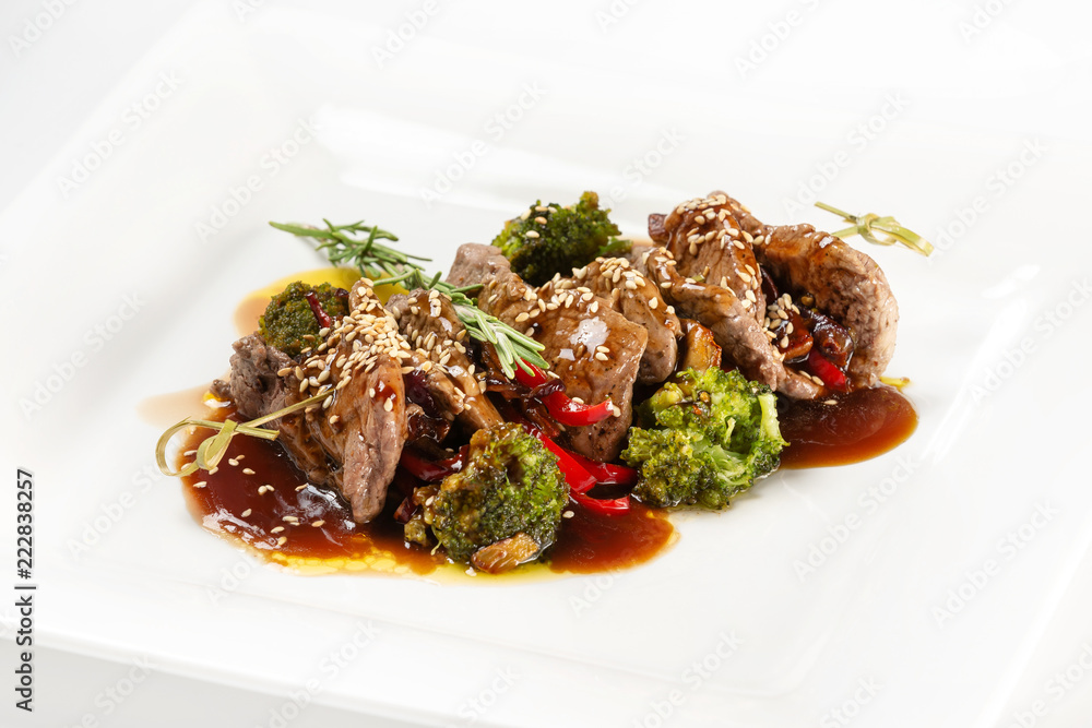 Closeup plate of delicious beef meat with brocolli, pepper and sauce isolated at white background. Closeup plate of delicious beef meat with brocolli, pepper and sauce isolated at white background.