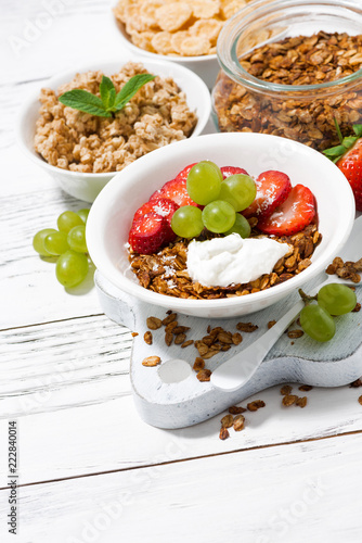 delicious healthy breakfast with fruits, granola on white background, vertical top view