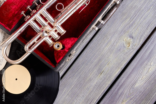 Vintage style musical objects. Trumpet, vinyl disc and musical notes on wooden boards with text space.
