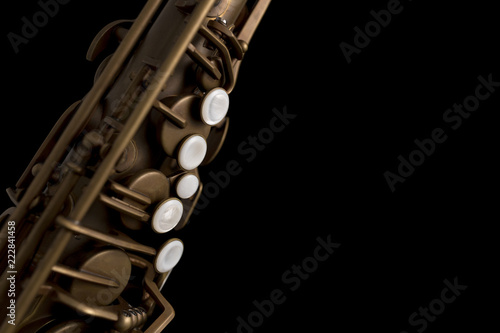 Matte finish saxophone with pearl keys on black background