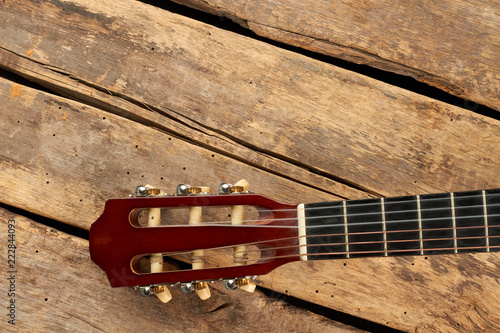 Guitar fretboard with strings. Part of classical guitar on old wooden boards.
