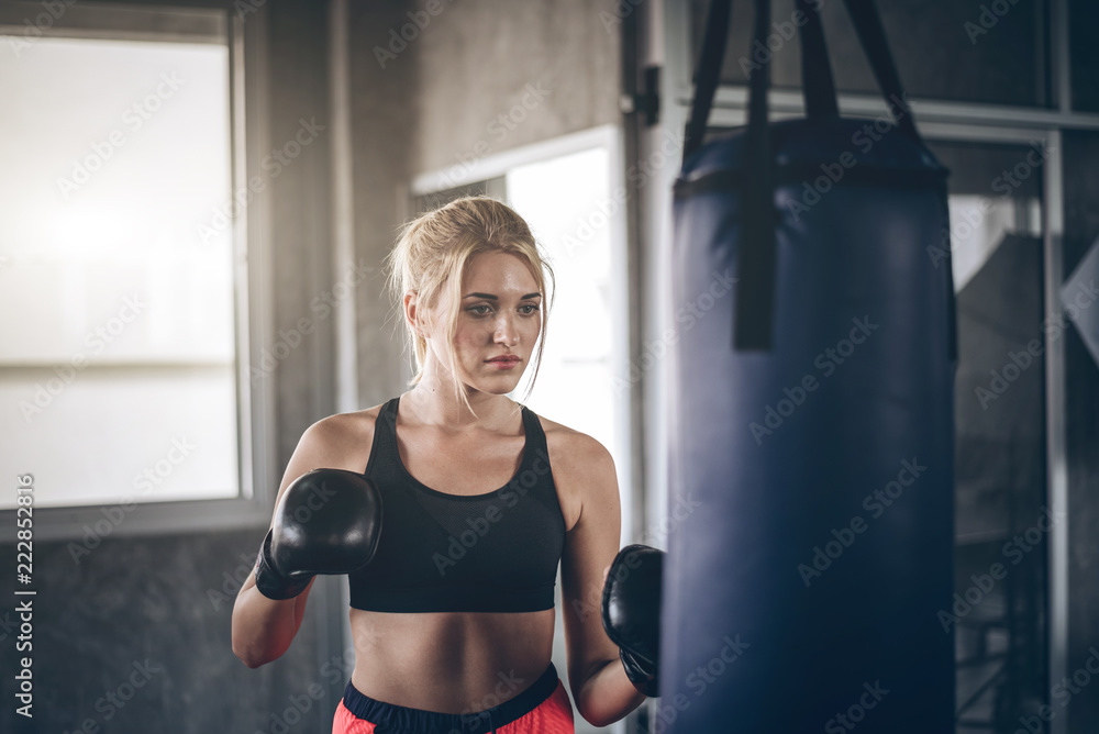 Woman exercising boxing.Attractive builder muscles women  in fitness gym