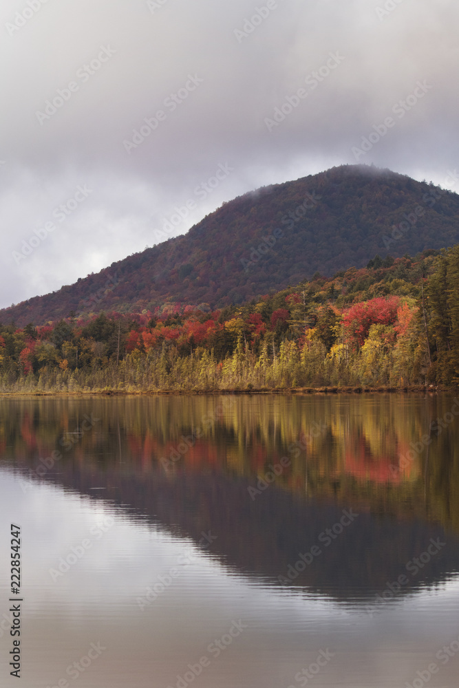fall foliage reflection in a pond in the adirondacks