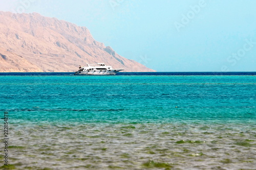 White ship in blue sea on mountain background in Red Sea