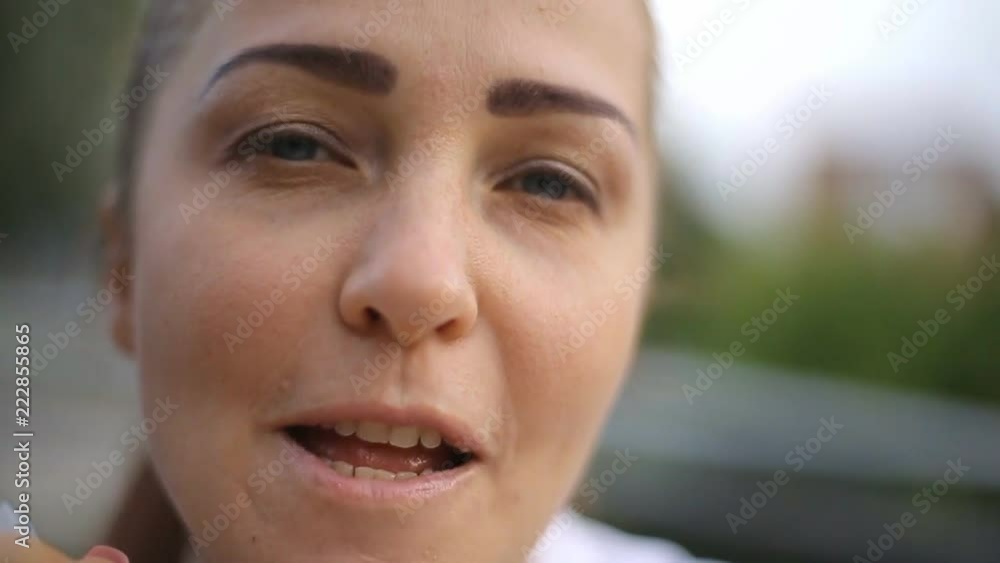 young Caucasian woman eating ice cream sitting at a table in a street cafe. young Caucasian woman eating ice cream sitting at a table in a street cafe.