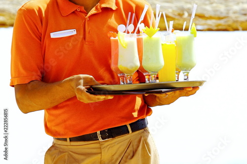 Waiter serving drinks, cocktail on the beach