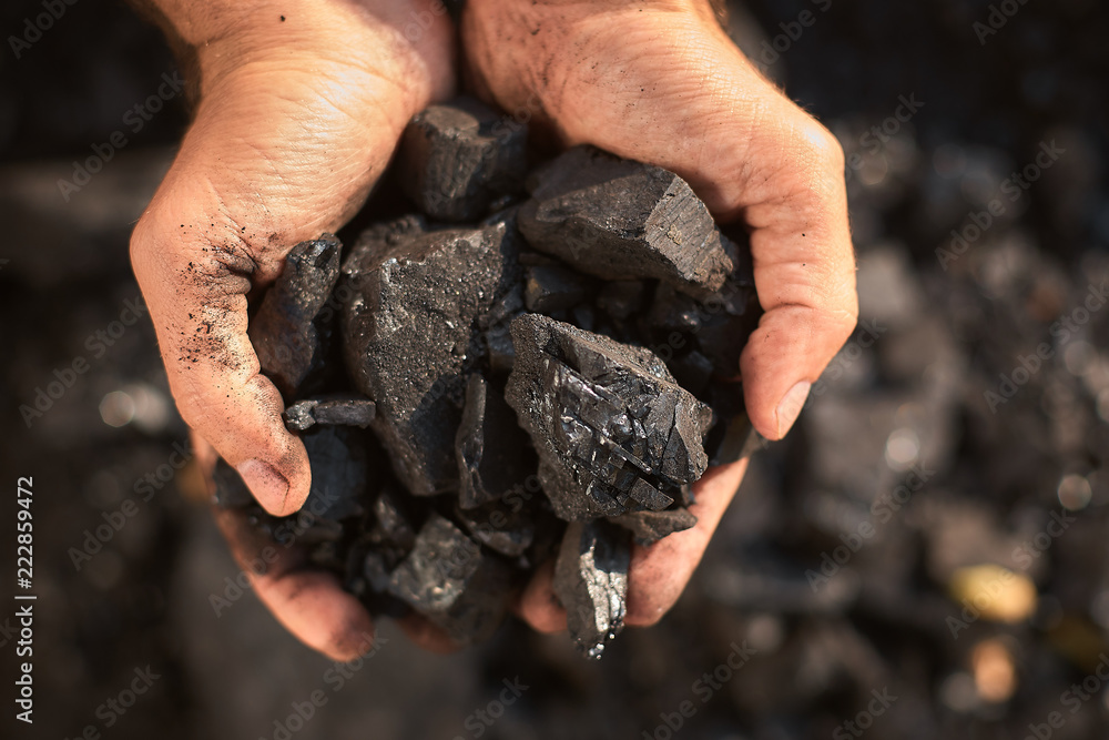 poor middle-aged man holding the hands of stone coal for sale to provide food for his family