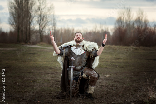 Quadro su tela Knight raised his hands to the sky in pleading, wearing a chain mail