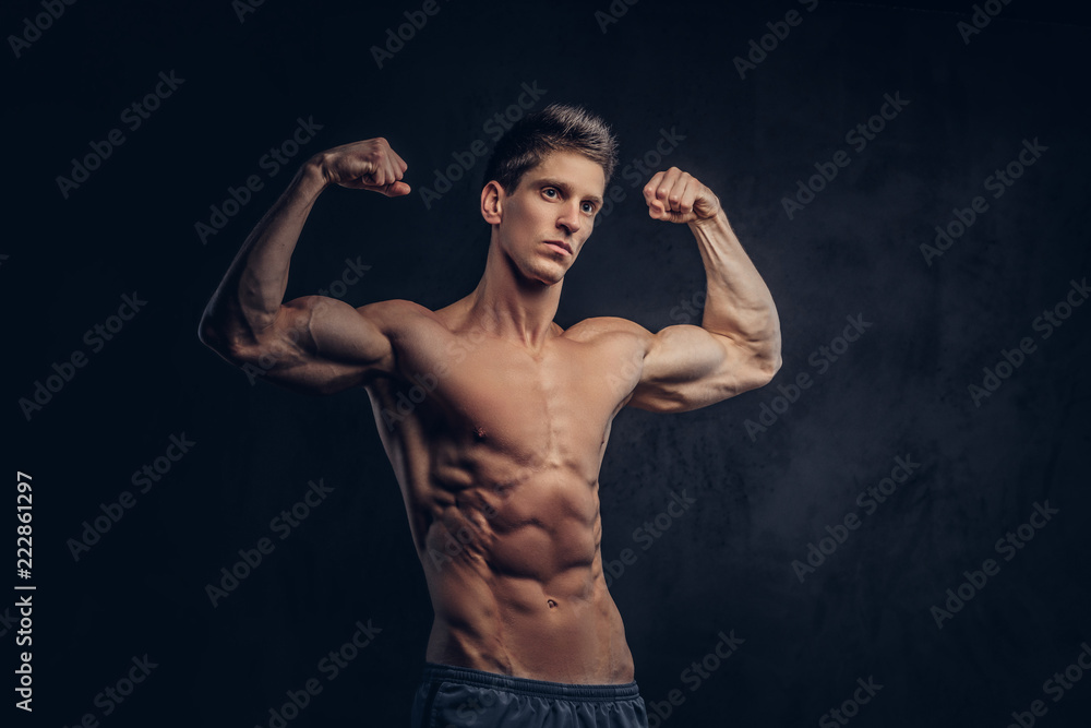 Handsome shirtless man with stylish hair and muscular ectomorph shows his biceps.