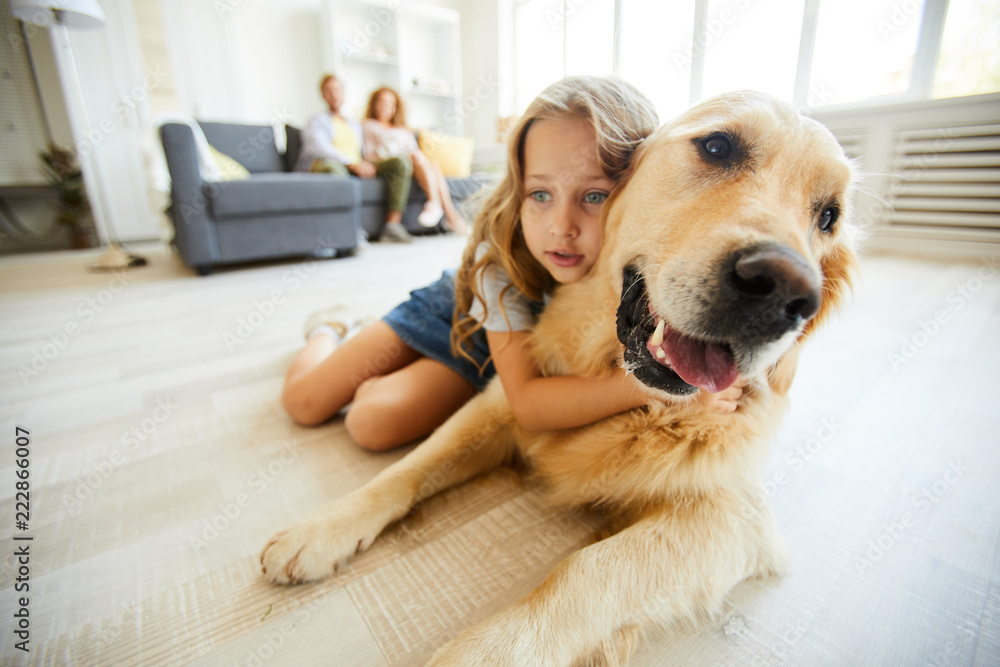 Restful purebred labrador and cute little girl lying on the floor of living-room at leisure Restful purebred labrador and cute little girl lying on the floor of living-room at leisure