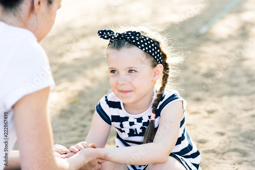 Mom hold a little daughter's hands in her own photo