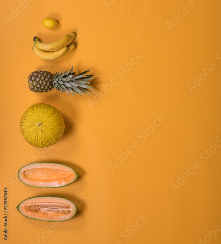 tropical exotic fruits on a yellow background, creative summer concept