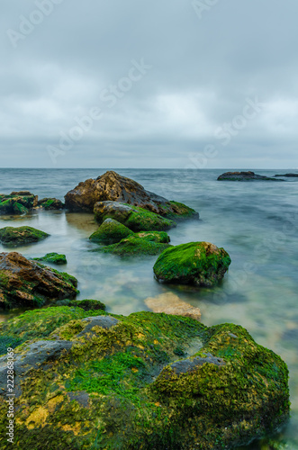 The photo of the stone on the beach on the long exposure