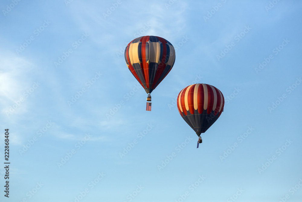 Fototapeta premium American flag and Nevada state flag flying with hot air balloons