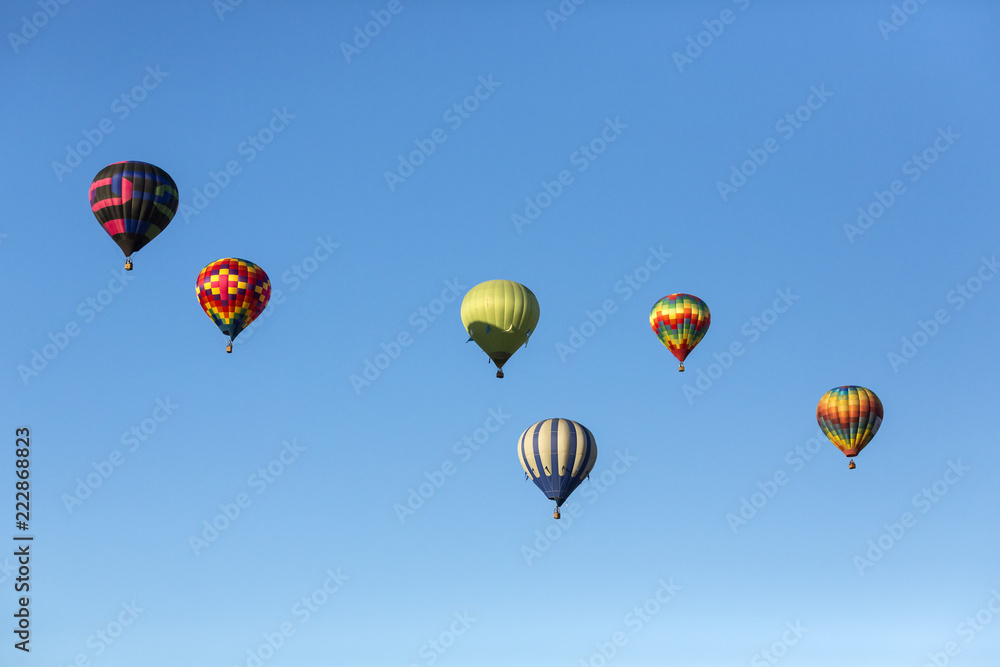 Obraz premium Hot air balloons flying in a beautiful blue clear sky