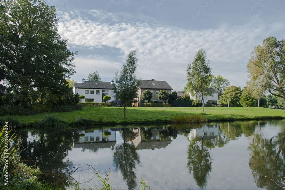 Reflection of a house and trees in the water in a park in Deventer, Netherlands