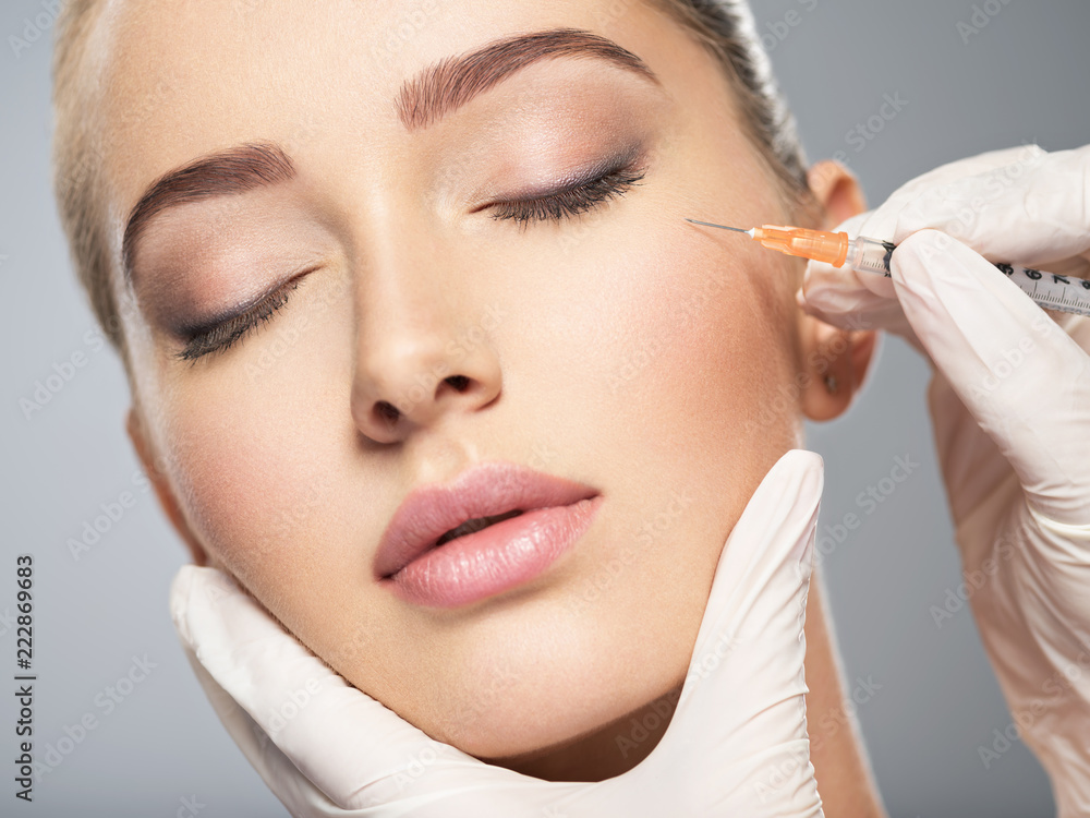 Woman getting cosmetic injection of botox near eyes