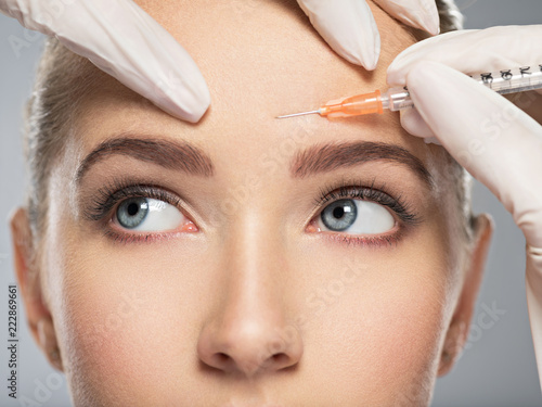 Obraz na plátně woman getting cosmetic botox injection in forehead