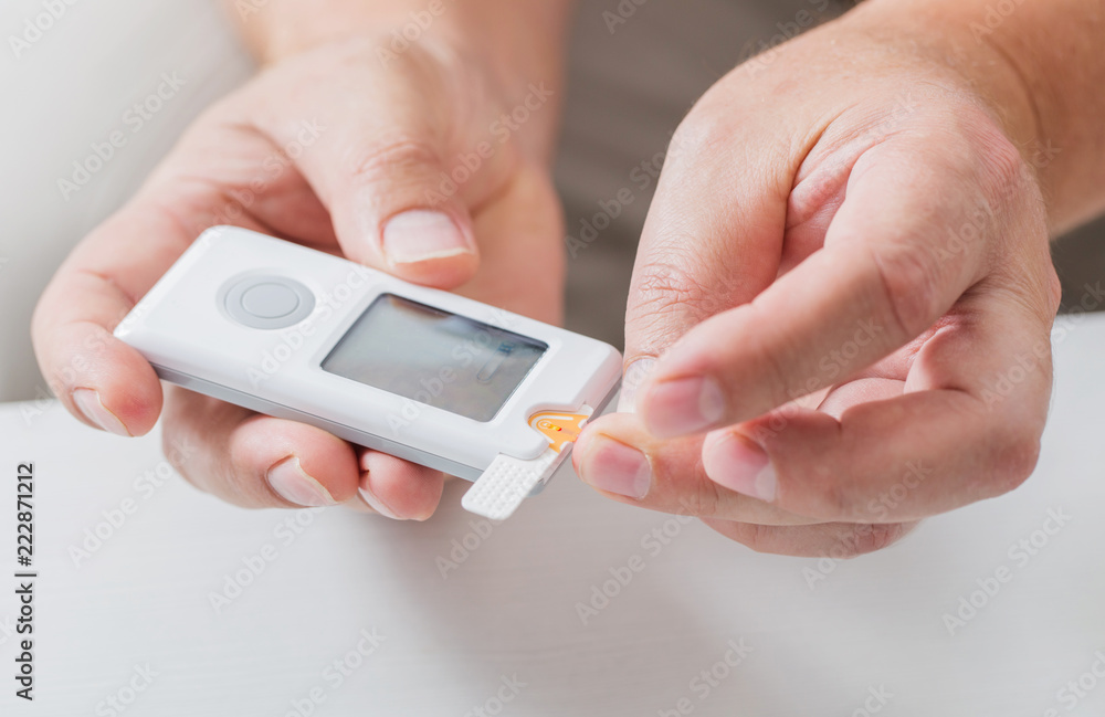 man measures sugar level with a glucometer man measures sugar level with a glucometer