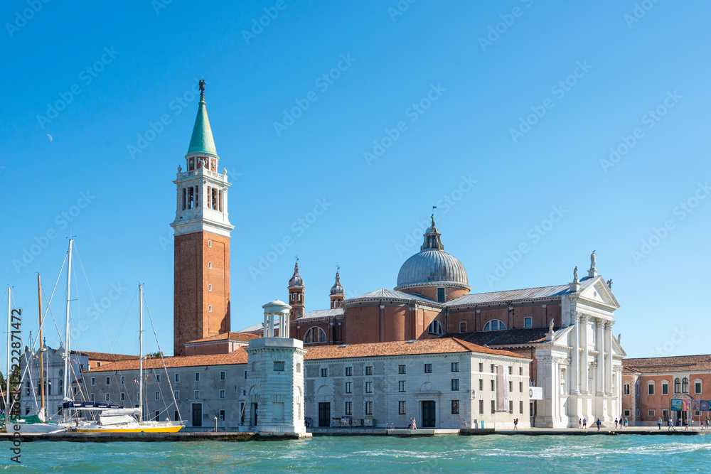 View of Church of San Giorgio Maggiore and Fondazione Giorgio Cini are located on one island of Venice, Italy. Palladio Venice architectures and parking yacht on island at Venice.
